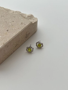 Macro detail of silver flower earrings with green zircon and micro-pave crystals