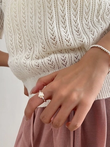 Detail of S925 silver freshwater pearl ring and beaded bracelet worn with knitwear