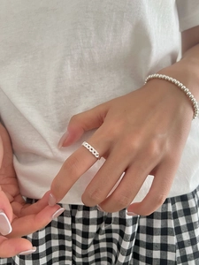 Detail of silver chain ring and beaded bracelet on model in minimalist Korean style