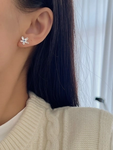 Détail de boucle d'oreille fleur en argent 925 avec pierre bleue sur le lobe