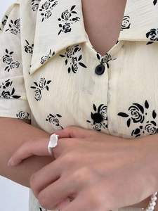Detailed view of sterling silver geometric ring with chalcedony on person's finger