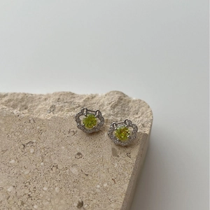 Exquisite 925 silver peace lock stud earrings with yellow-green stones on stone stand