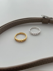 Detail of woven chain adjustable rings in gold and silver finish with zircon stones