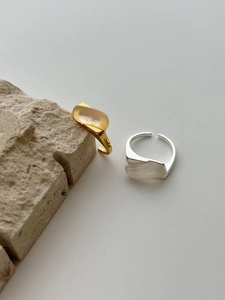 Detailed view of minimalist 925 silver rings with chalcedony on a natural stone base