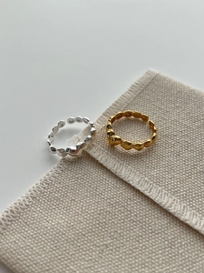 Macro shot of 925 sterling silver heart-shaped adjustable rings in gold and silver