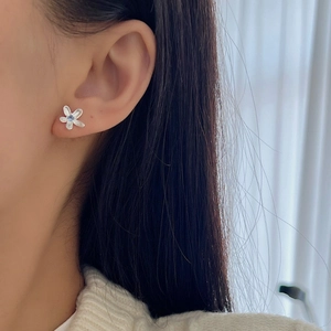 Boucles d'oreilles fleurs en argent 925 avec pierre bleue portées par un mannequin