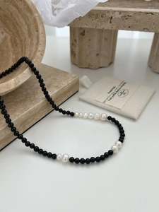 Macro view of 925 silver necklace with black agate beads and natural baroque pearls