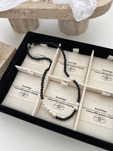 Macro shot of 925 silver black onyx and gradient pearl necklace in a premium velvet box