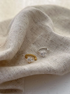 Detail of 925 silver ear cuff set with heart-shaped zirconia in gold and silver finish