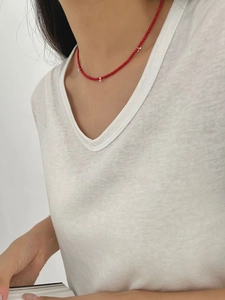 Détail du collier en perles rouges et argent S925 porté sur le cou d'un mannequin