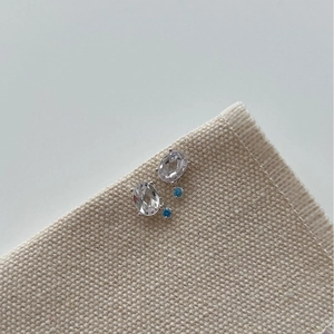 925 sterling silver earrings with blue crystal and faceted clear stone on linen fabric