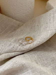 Detailed view of gold and silver heart-shaped 925 sterling silver rings with zircon stones