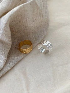 Detail of gold and silver hammered texture adjustable open rings on linen fabric