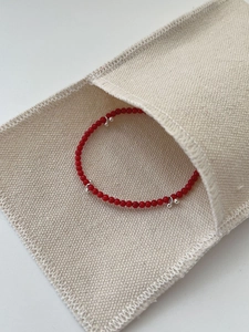 Detailed macro view of an S925 silver beaded bracelet with small red agate stones