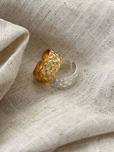 Detailed view of wide open rings with irregular hammered texture in gold and silver