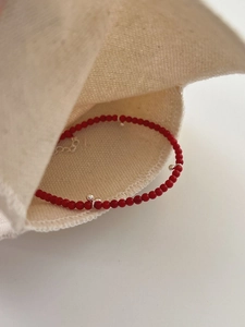 Detailed macro view of S925 sterling silver red beaded bracelet with adjustable chain