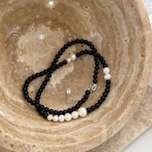 925 silver necklace with black onyx beads and gradient pearls in a beige stone bowl