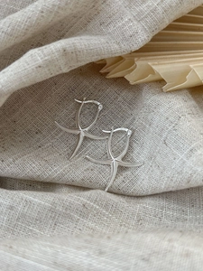 Detailed view of S925 sterling silver starfish stud earrings on a rustic linen background