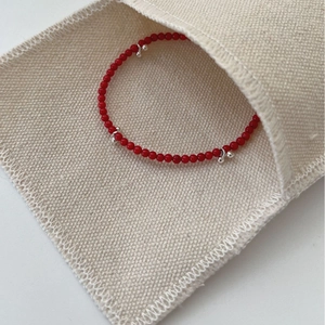 Minimalist S925 sterling silver beaded bracelet with red beads and silver charms in a pouch