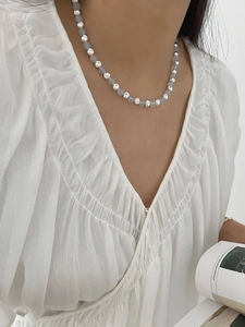 Detailed view of sapphire beaded sterling silver necklace worn on an elegant model