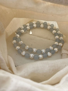 Detail of silver brushed metal beads and blue translucent beads on a double-layer necklace