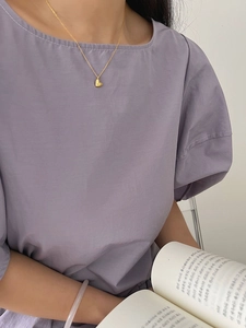 Détail d'un collier pendentif cœur en argent sterling 925 doré porté avec élégance
