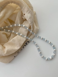 Detail of 925 silver beads and blue sapphire stones on necklace with linen pouch