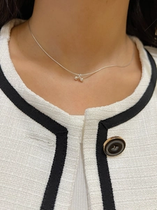 Close-up of S925 sterling silver cherry pendant necklace on a textured tweed outfit