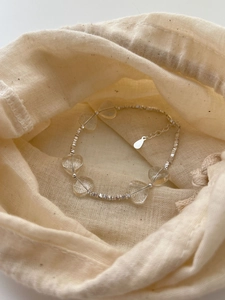 Detailed macro view of 925 silver beaded heart bracelet on a soft fabric pouch