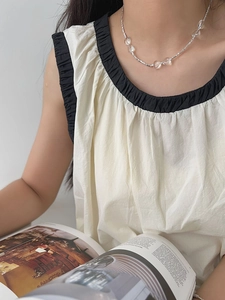 Detail of silver necklace with transparent heart charms worn on a casual model outfit