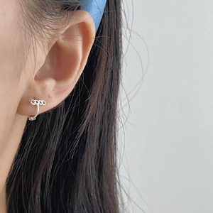 Minimalist 925 sterling silver hoop earrings with GOOD letter design on model's ear