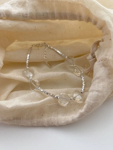 Detailed macro view of 925 silver beaded bracelet with heart crystals on linen bag