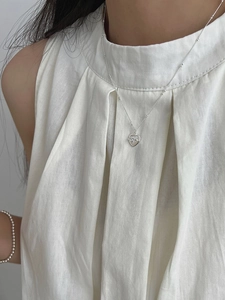 Détail d'un collier avec pendentif coeur à motif épines et élégant bracelet en perles
