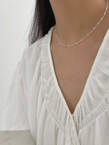 Detail view of a 925 sterling silver choker necklace with round sequins on a model