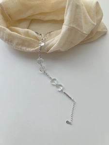 Detail of S925 sterling silver heart crystal bracelet on minimalist beige linen bag