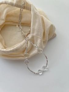 Detailed view of silver minimalist necklace with crystal beads and linen pouch
