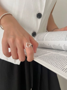 Gros plan d'une bague cœur ajourée en argent 925 avec son bracelet en perles assorti