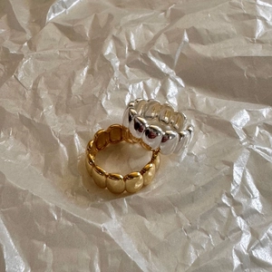 Minimalist s925 silver and gold oval rings with a polished textured finish on white paper