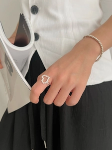 Gros plan sur une bague coeur évidée et un bracelet perlé en argent 925 pour femme