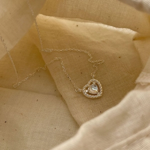 Minimalist S925 sterling silver heart necklace with moonstone on beige fabric