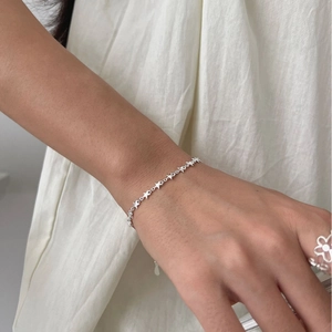 Minimalist S925 sterling silver star chain bracelet for women on white fabric background
