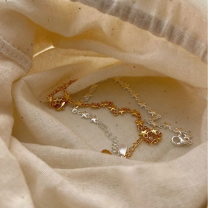 Elegant S925 sterling silver star bracelets in gold and silver finish on linen bag