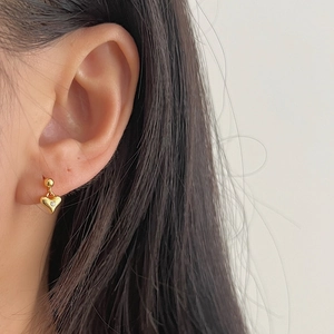 Elegant gold heart earrings with small zircon stone shown on model for stylish look
