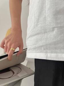 Detailed view of Italian style brushed gold ring with floral motifs on model hand