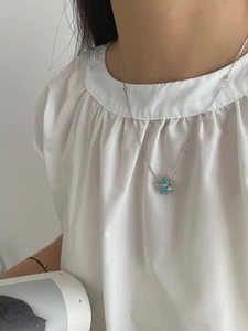 Detail of 925 silver bamboo chain necklace featuring a blue pear-shaped sapphire pendant
