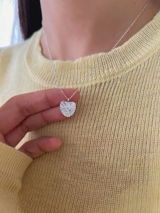 Close-up of S925 sterling silver heart pendant necklace with radiant zircon on a model