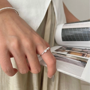 Minimalist silver ring with zircon beads and hammered metal bracelet on a model