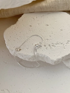 Macro view of 925 sterling silver croissant charm on a delicate snake bone bracelet