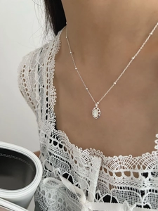 Détail d'un collier en argent sterling 925 avec pendentif ovale en nacre et chaîne à perles