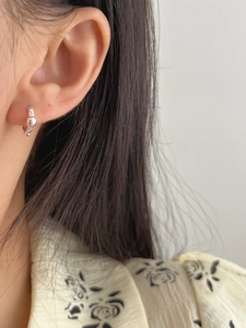 Detail shot of silver S925 sterling silver mini hoop earrings with irregular texture